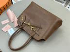 Brown leather handbag with braided strap ties and gold-toned hardware