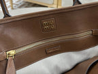 Brown leather handbag interior close-up with zip pocket and metal zipper pull