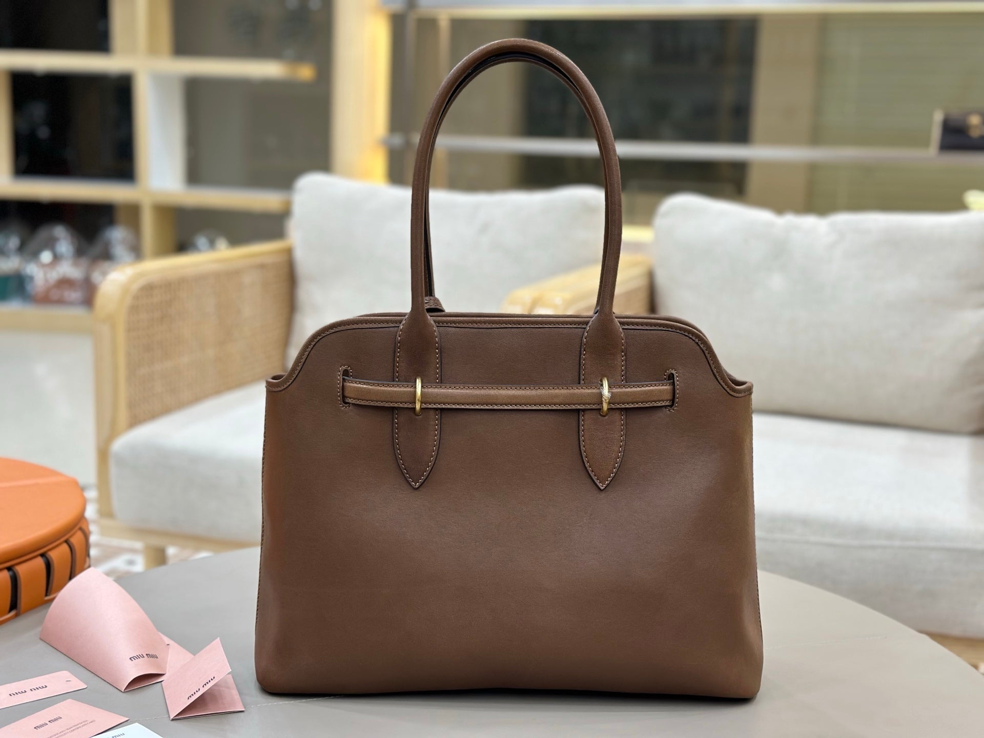 Brown leather handbag with double top handles and front strap hardware