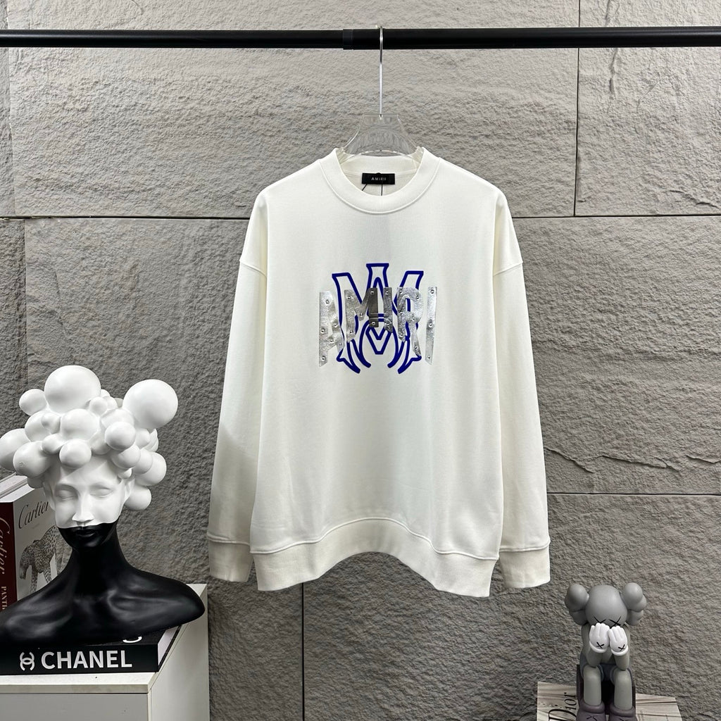 White Amiri crewneck sweatshirt with blue graphic lettering and silver metallic panels