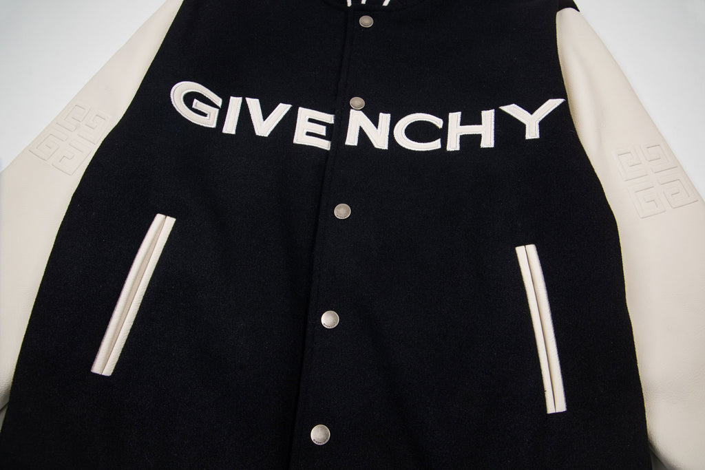 Black varsity jacket front with GIVENCHY logo, snap buttons, and striped ribbed cuffs