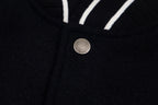 Black varsity jacket front with round metal snap button and striped trim