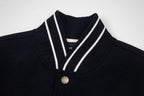 Black varsity jacket collar with cream V-striped trim and snap button placket