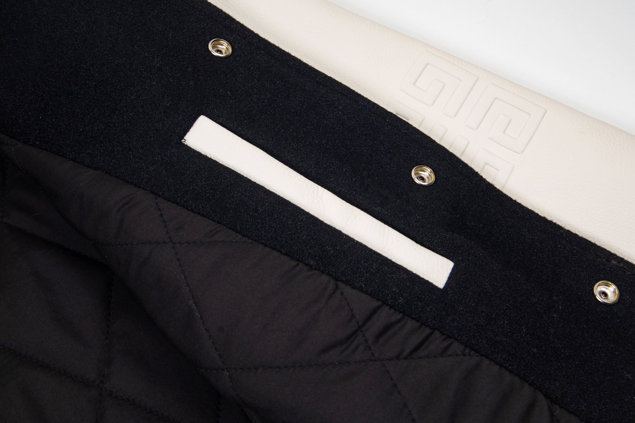 Givenchy black jacket front with white bar stripe, snaps, and quilted panel