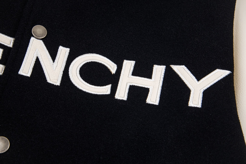 Close-up of GIVENCHY lettering on black varsity jacket front