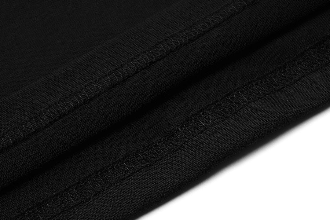 Black T-shirt hem with visible stitching and ribbed cuff edge