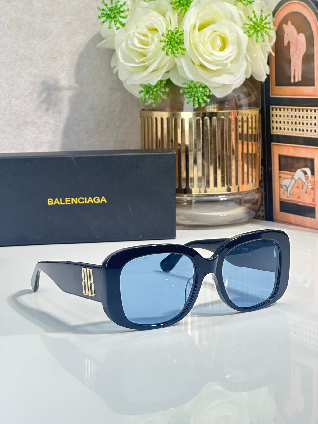 Blue sunglasses with dark lenses and BB logo on the temple