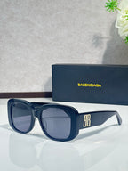 Blue sunglasses with rounded-square frames, dark lenses, and BB logo on the arm