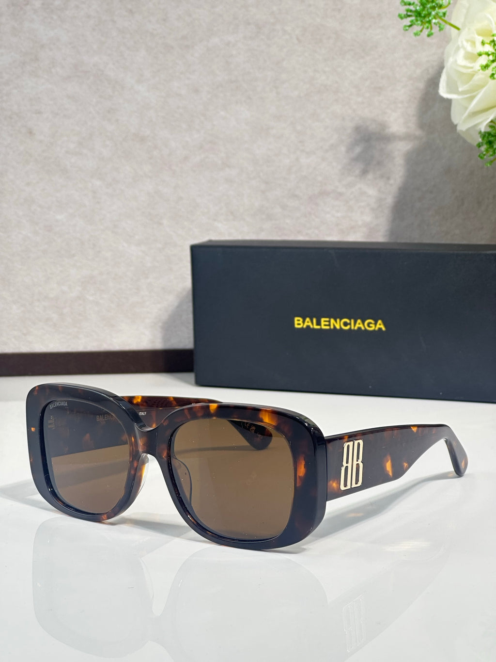 Tortoiseshell sunglasses with dark lenses and BB logo on the side