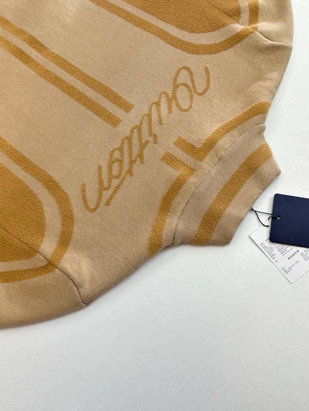 Beige knit fabric with Louis Vuitton script and gold geometric stripes