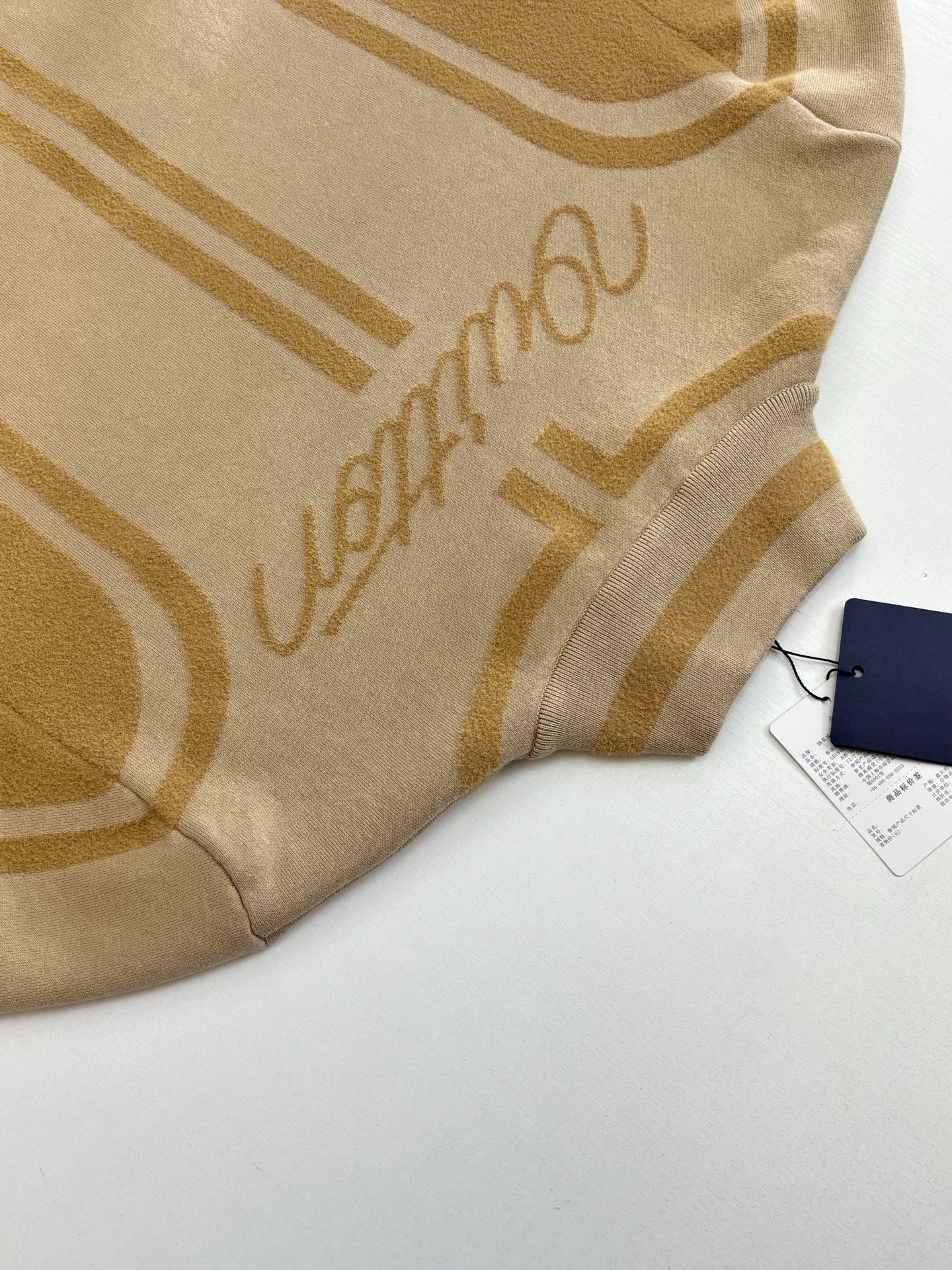 Beige knit fabric with Louis Vuitton script and gold geometric stripes