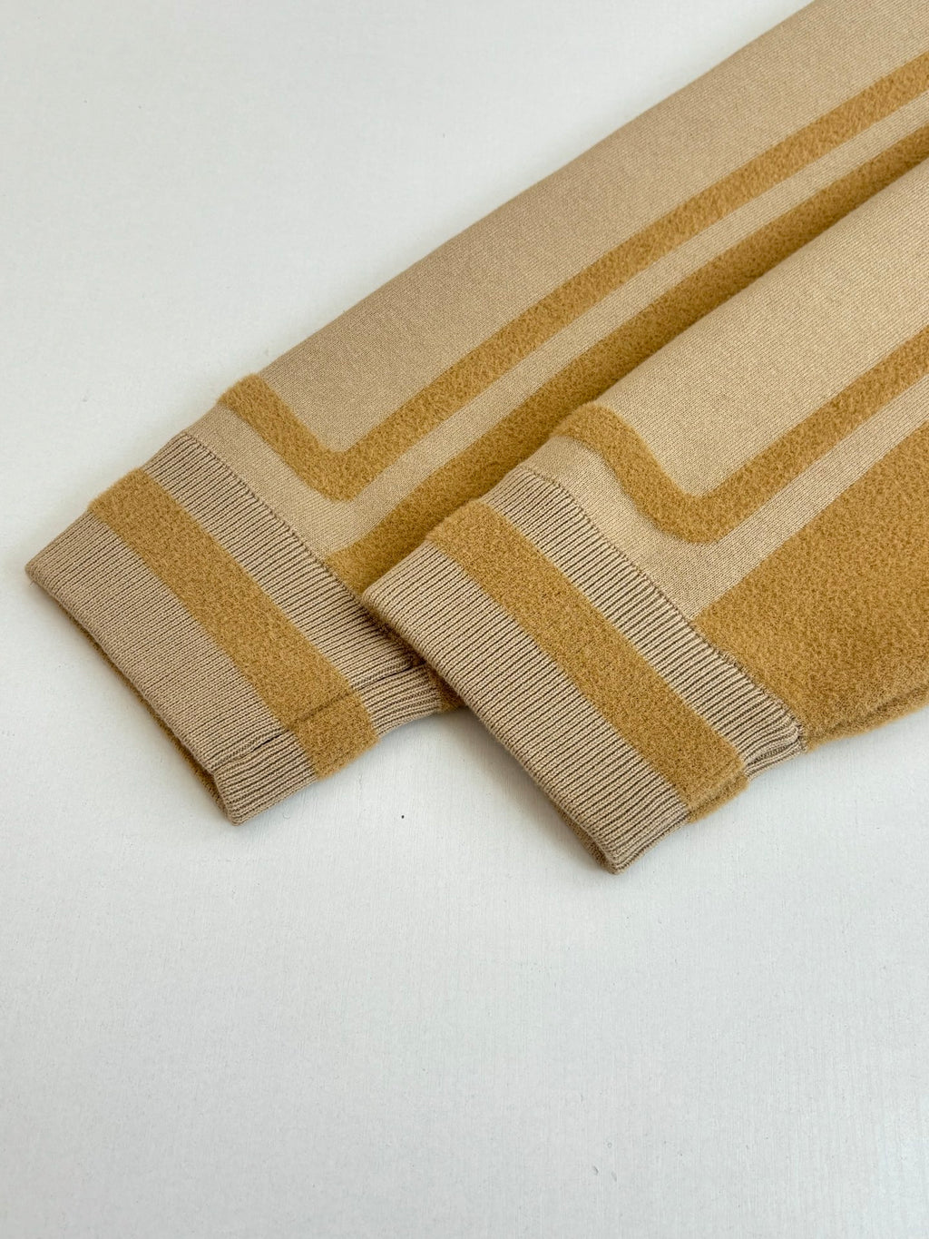 Beige knit cuffs with gold stripe bands and ribbed knit edges