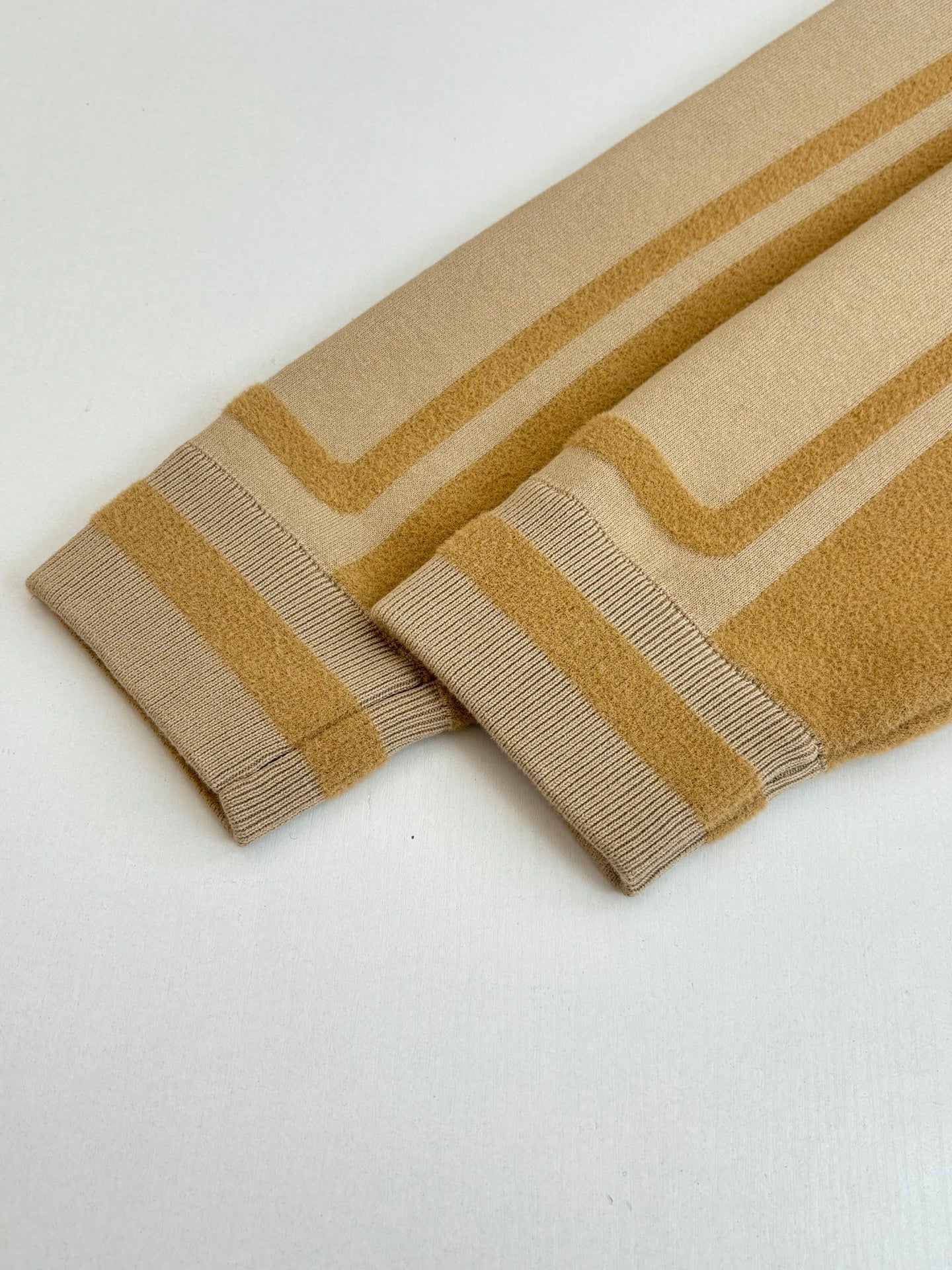 Beige knit cuffs with gold stripe bands and ribbed knit edges