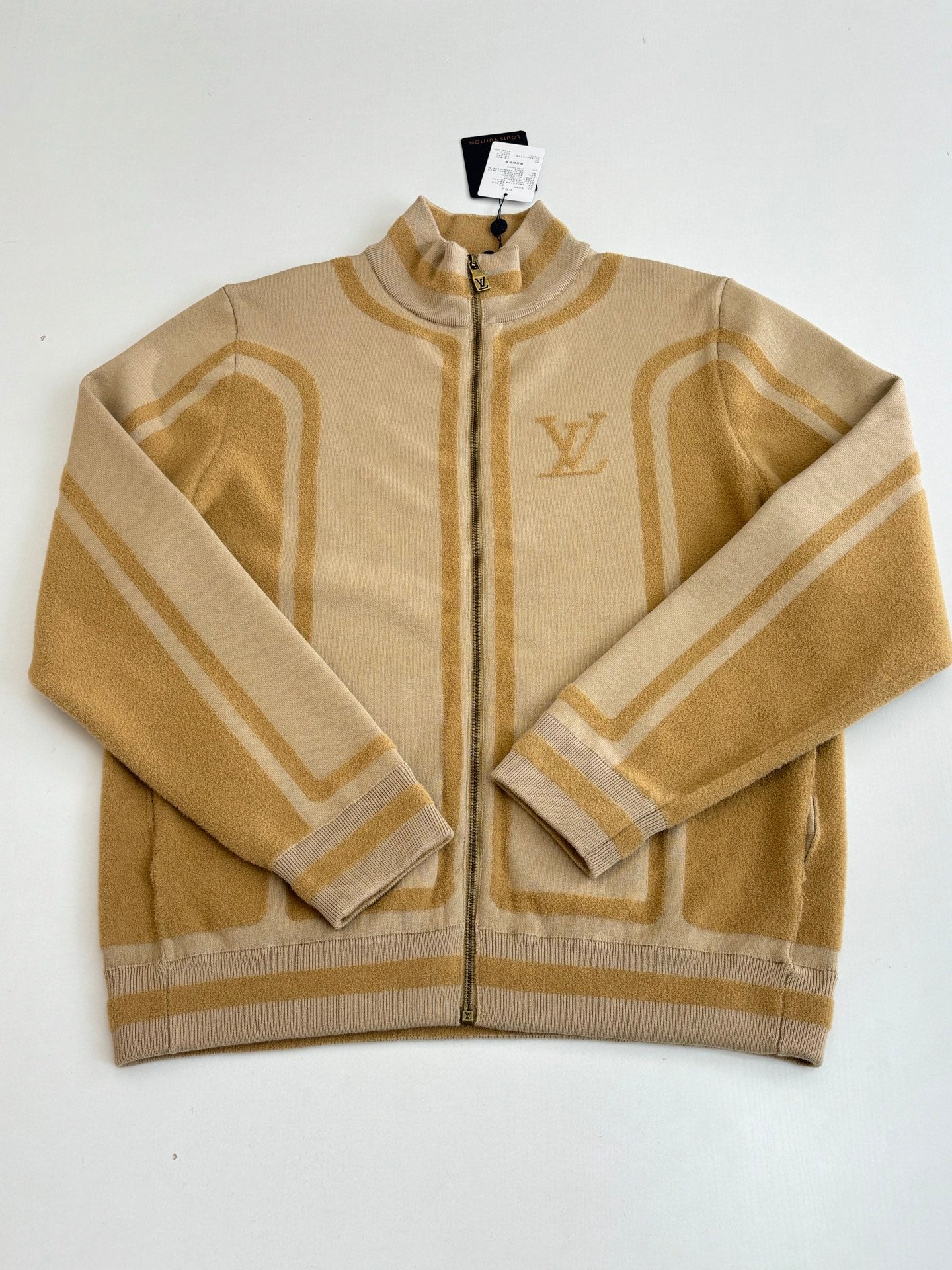 Beige knit zip jacket with stand collar, gold trim, and Louis Vuitton emblem