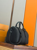 Men's dark teal leather duffel bag with rounded profile and side buckle detail