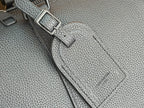Dark teal leather duffel bag side hardware and stitched label detail