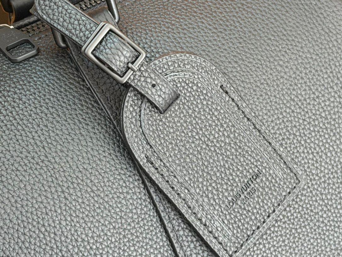 Dark teal leather duffel bag side hardware and stitched label detail