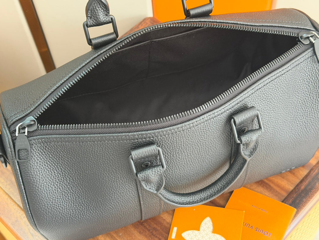 Dark teal leather duffel bag with top zipper, front pocket, and carry handles