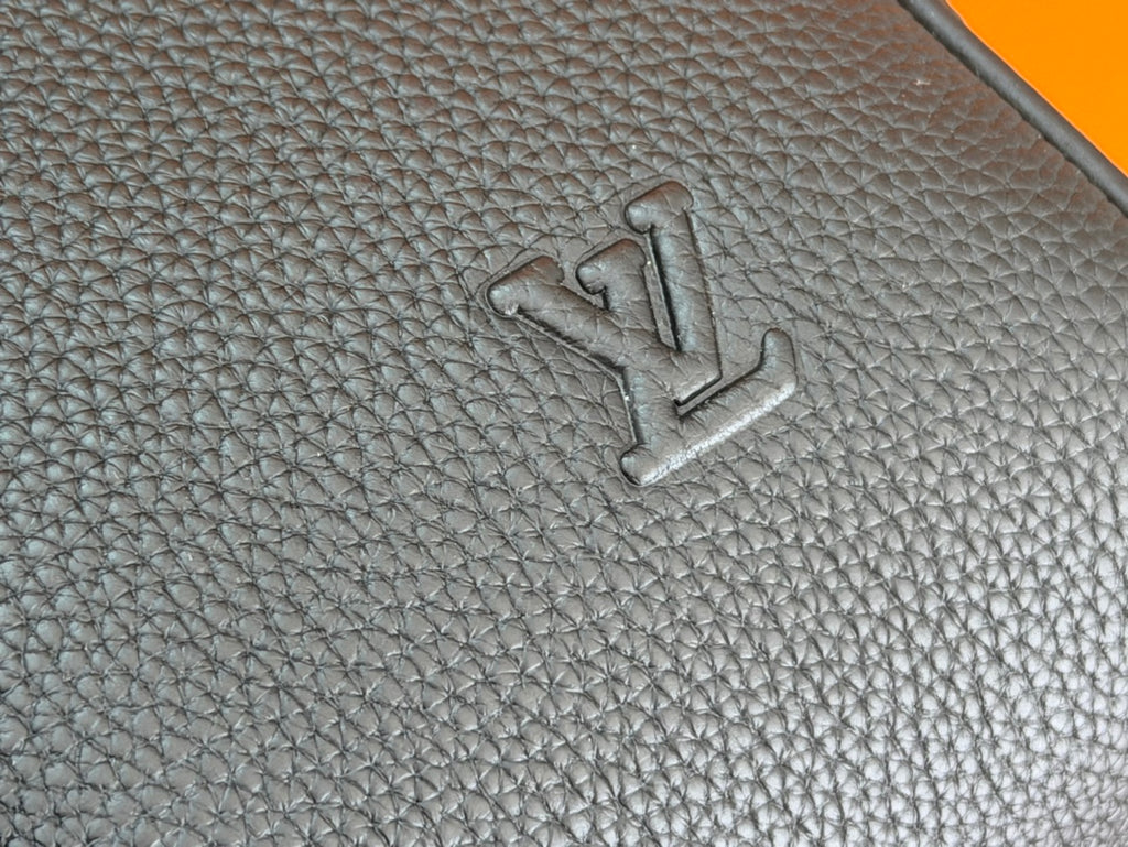 Embossed logo on dark teal textured leather duffel bag panel