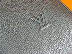 Embossed logo on dark teal textured leather duffel bag panel
