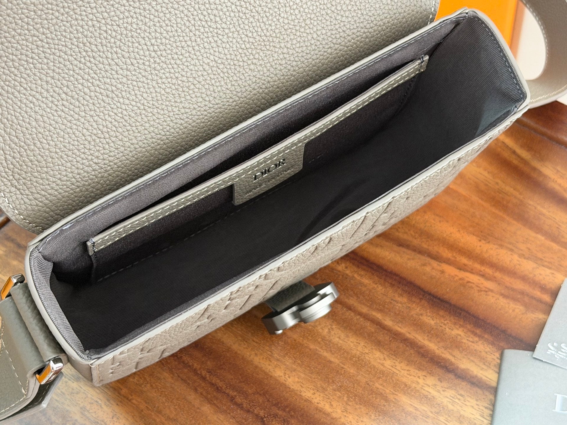 Dior men's bag interior view with dark lining and open top compartment