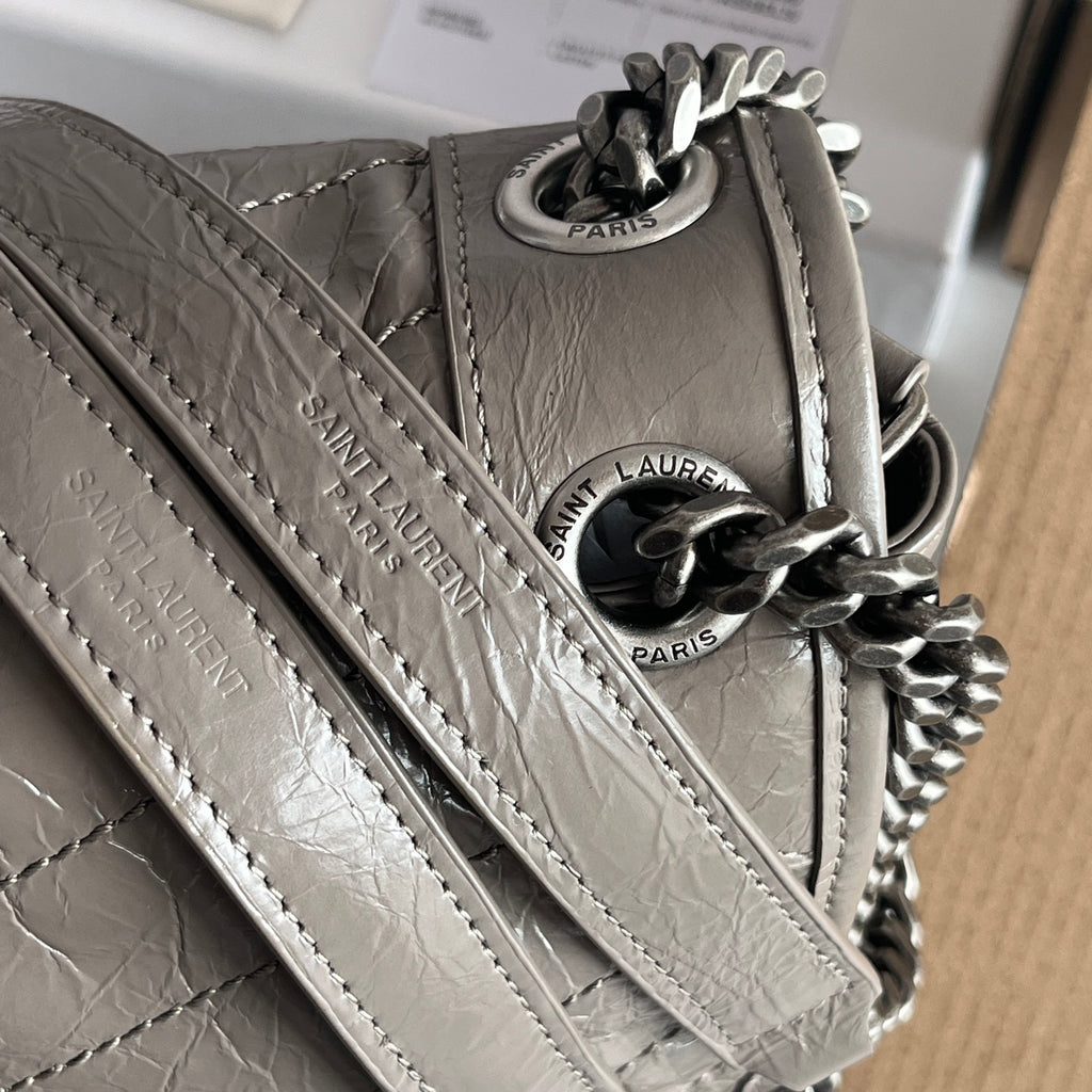 Silver leather shoulder bag close-up of strap and chain links with Paris tags