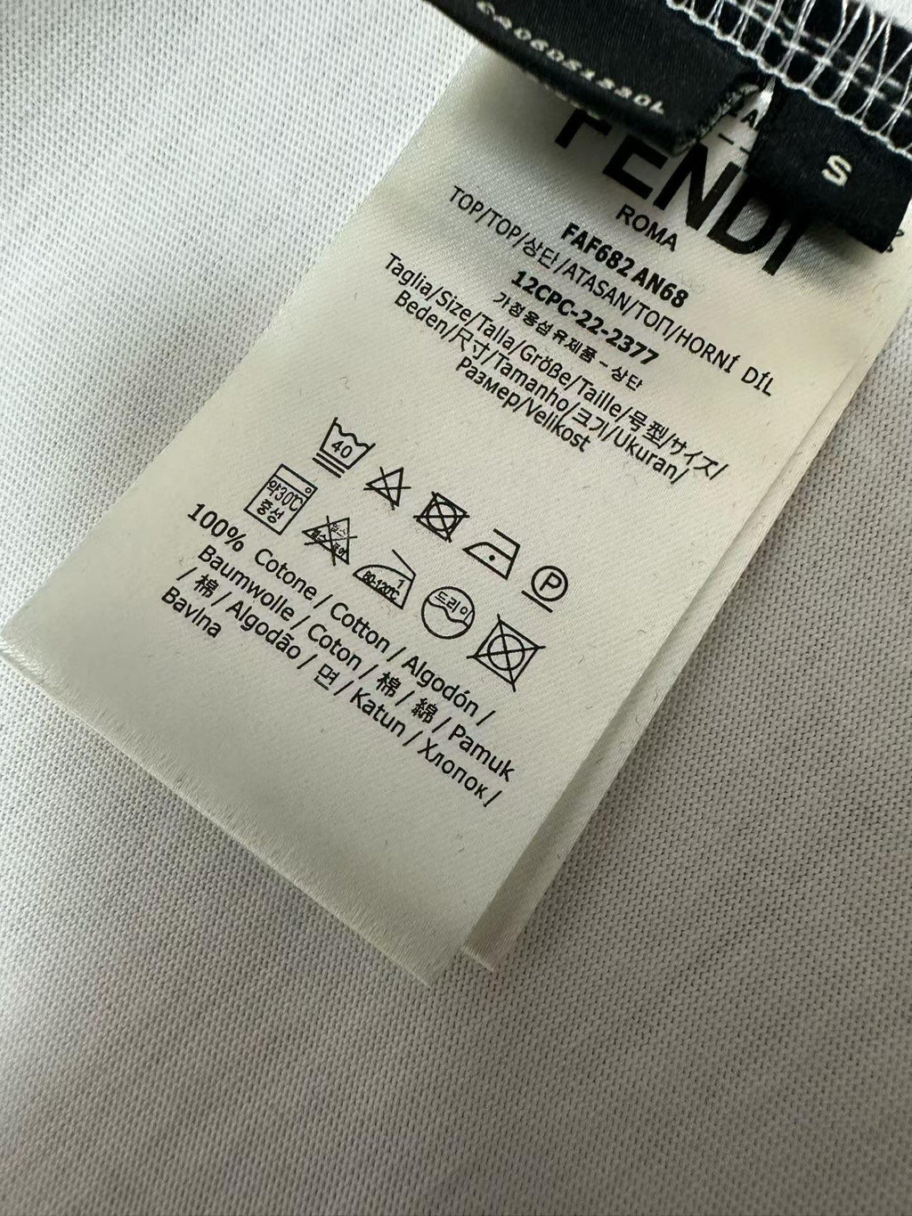 White T-shirt fabric label with care symbols and size details