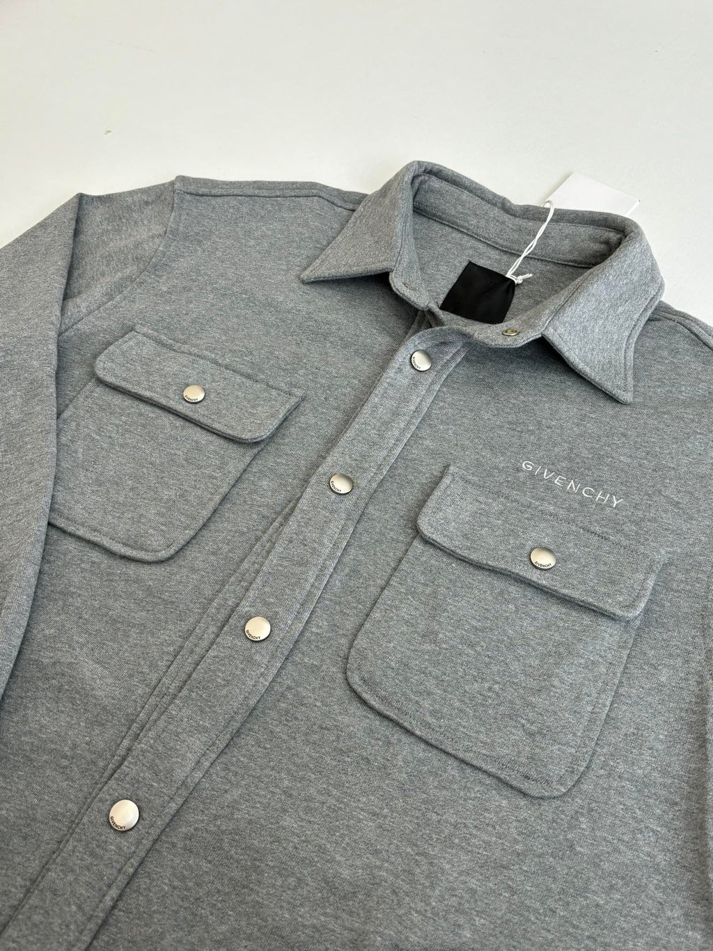 Gray Givenchy button-up jacket with two front flap pockets and snap buttons