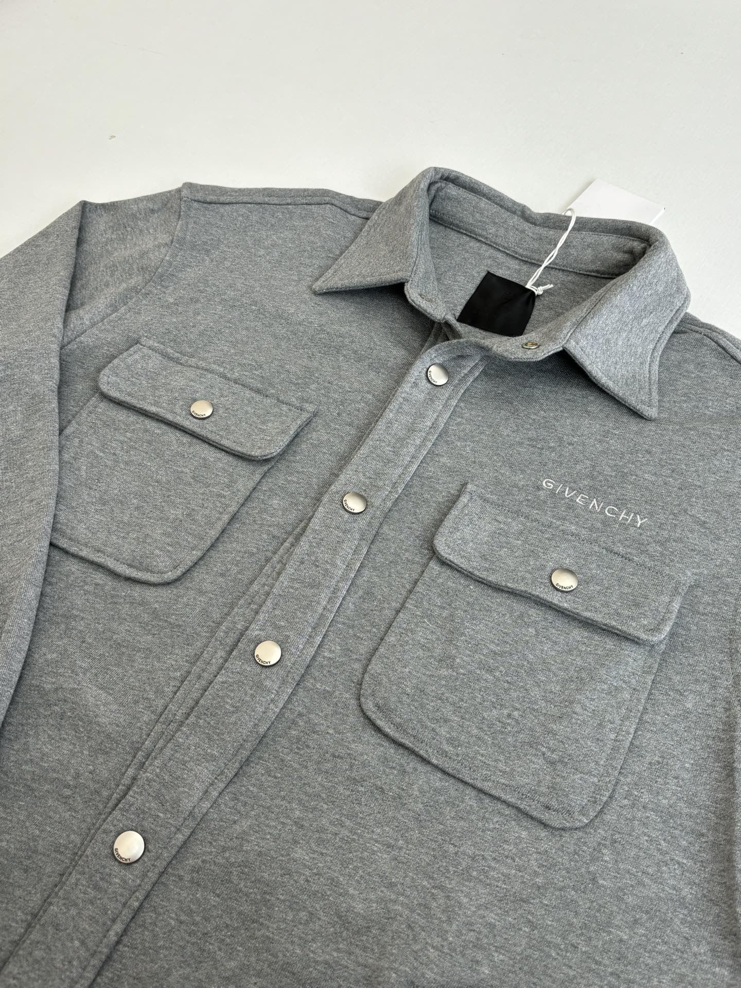 Gray Givenchy button-up jacket with two front flap pockets and snap buttons