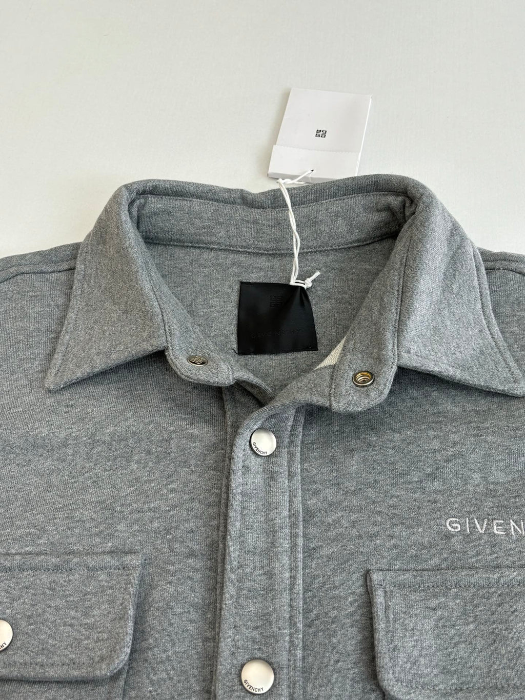 Gray Givenchy jacket collar with snap buttons and chest pocket detailing