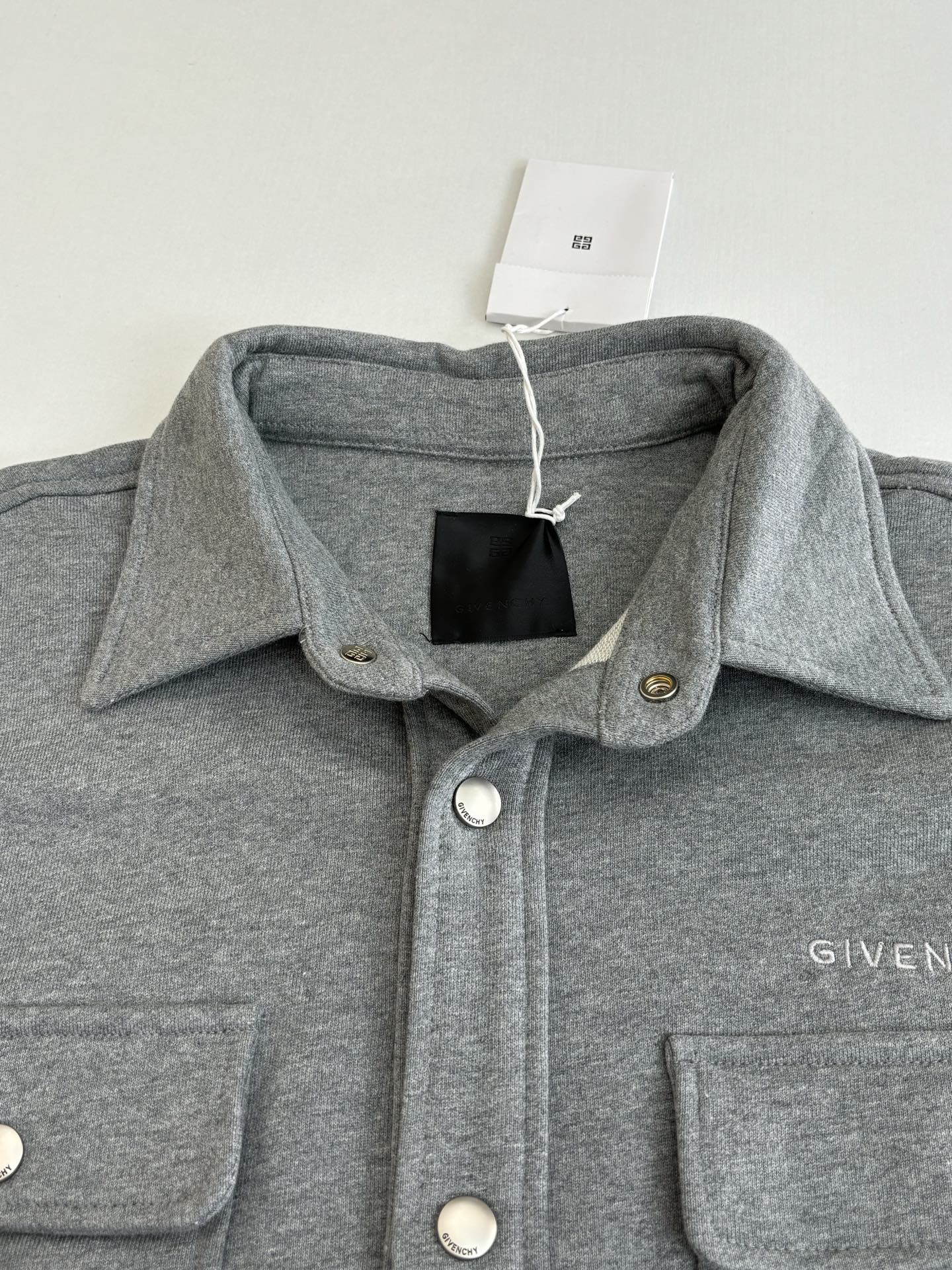 Gray Givenchy jacket collar with snap buttons and chest pocket detailing