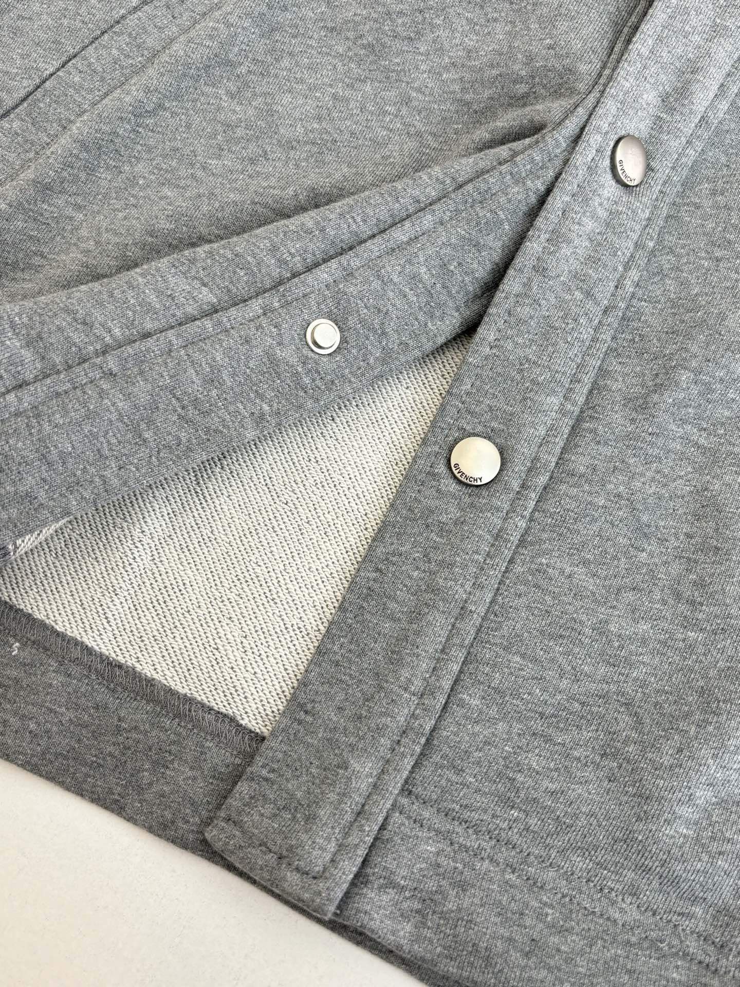 Gray Givenchy jacket laid flat with button placket and cuff details