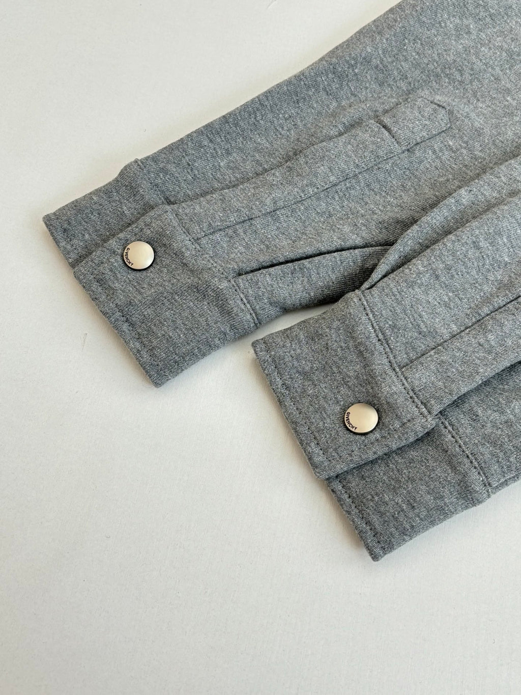 Gray Givenchy jacket cuffs with snap buttons and front placket panel