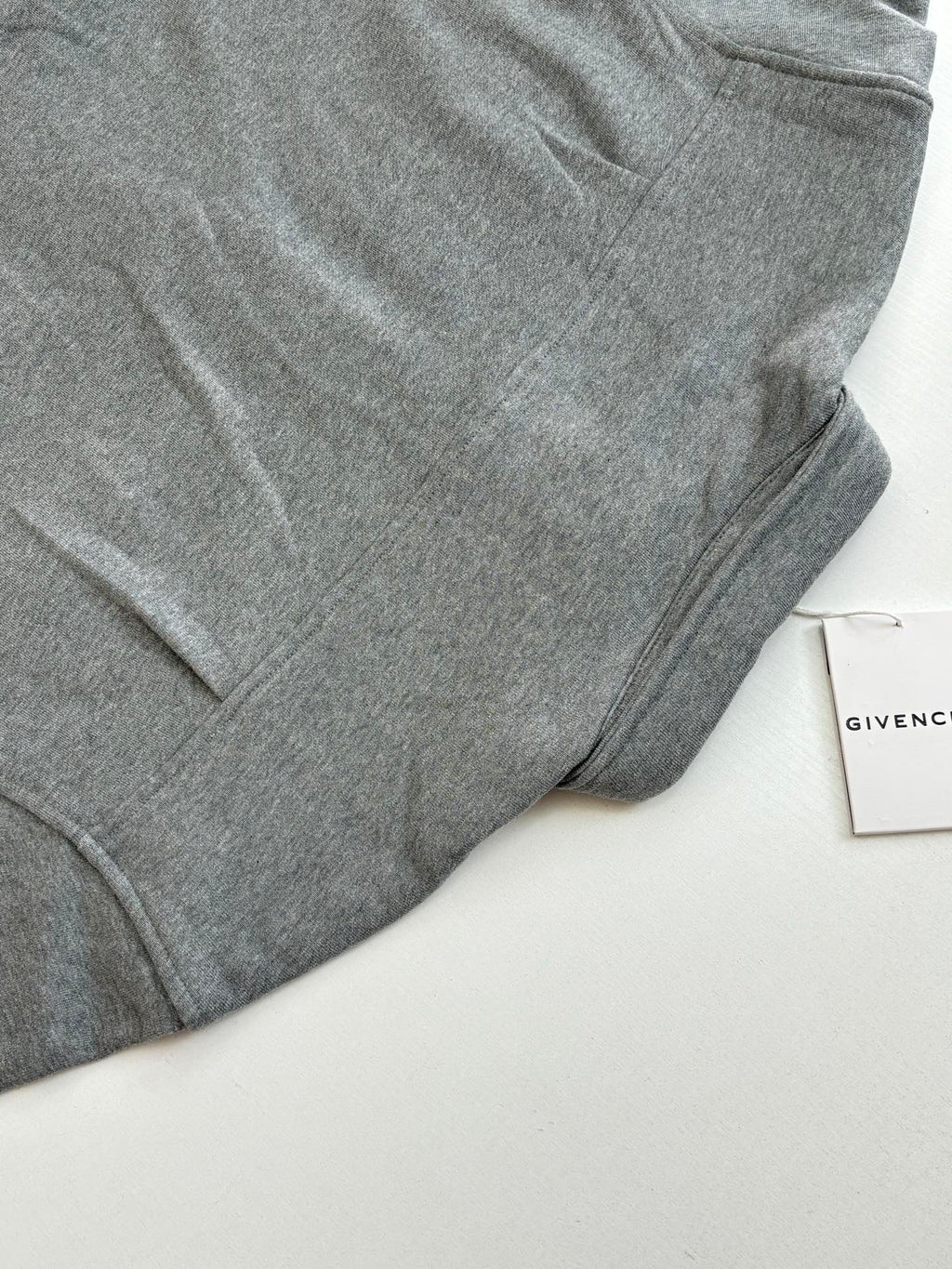 Gray Givenchy long-sleeve jacket sleeve and curved hem detail
