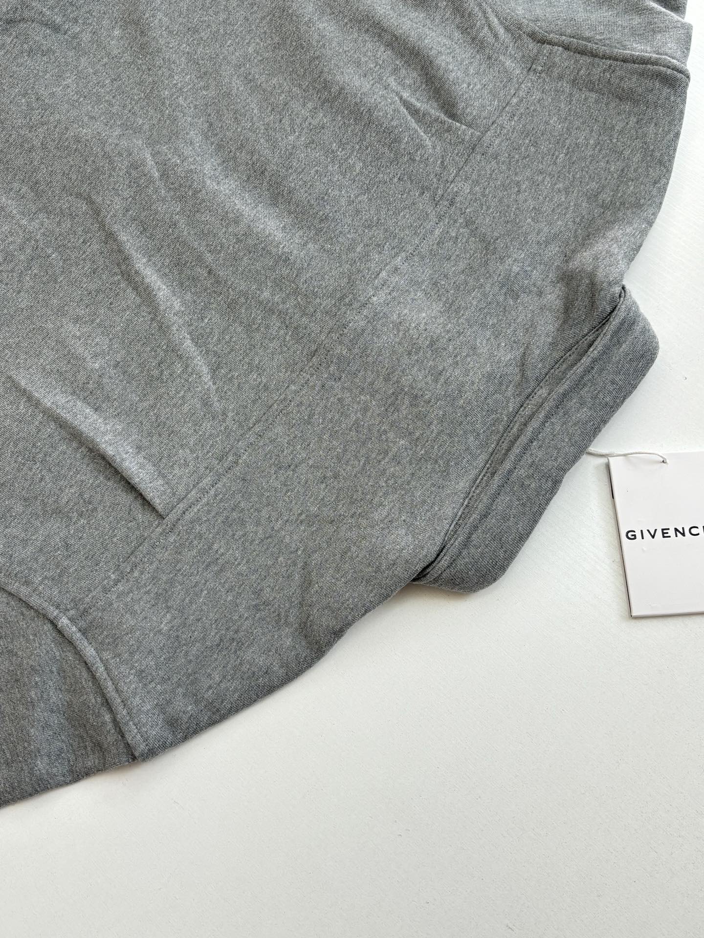 Gray Givenchy long-sleeve jacket sleeve and curved hem detail
