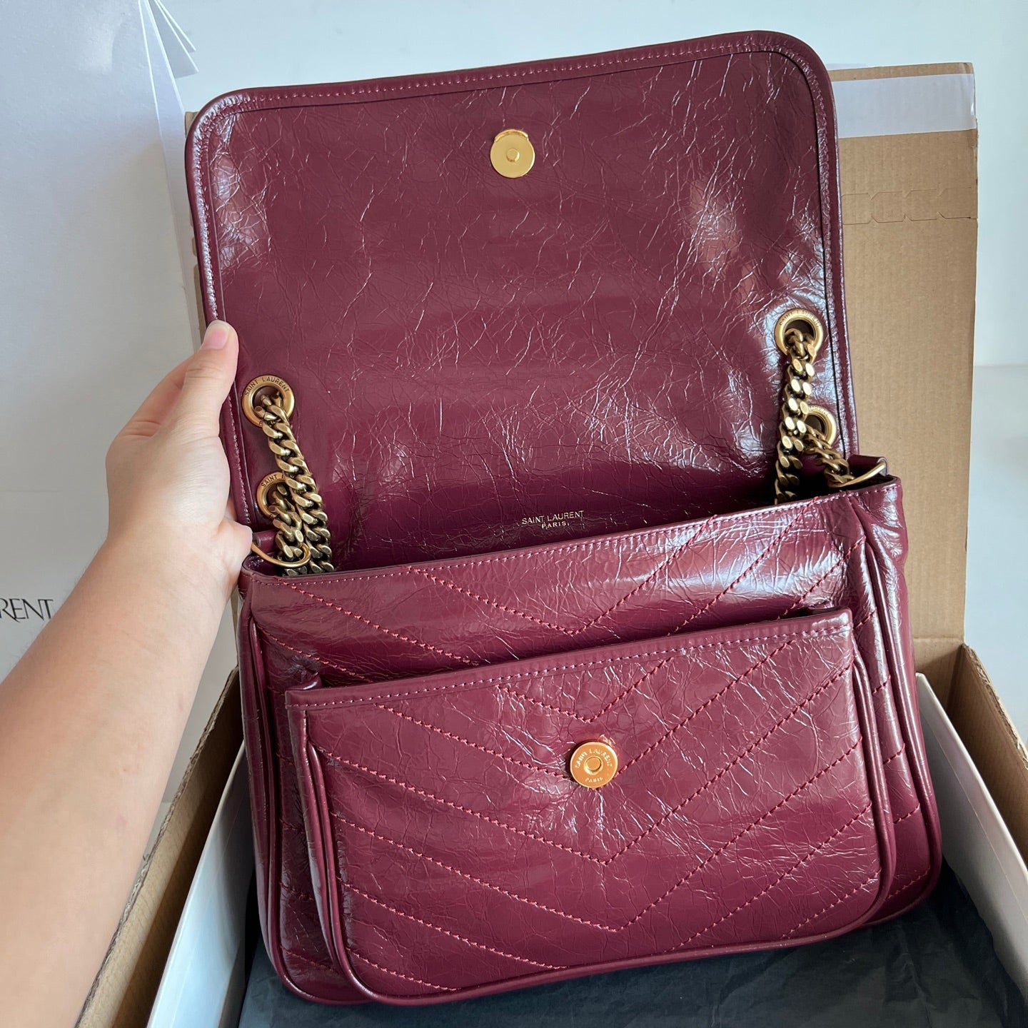 Two burgundy Saint Laurent leather shoulder bags with gold chain and flap