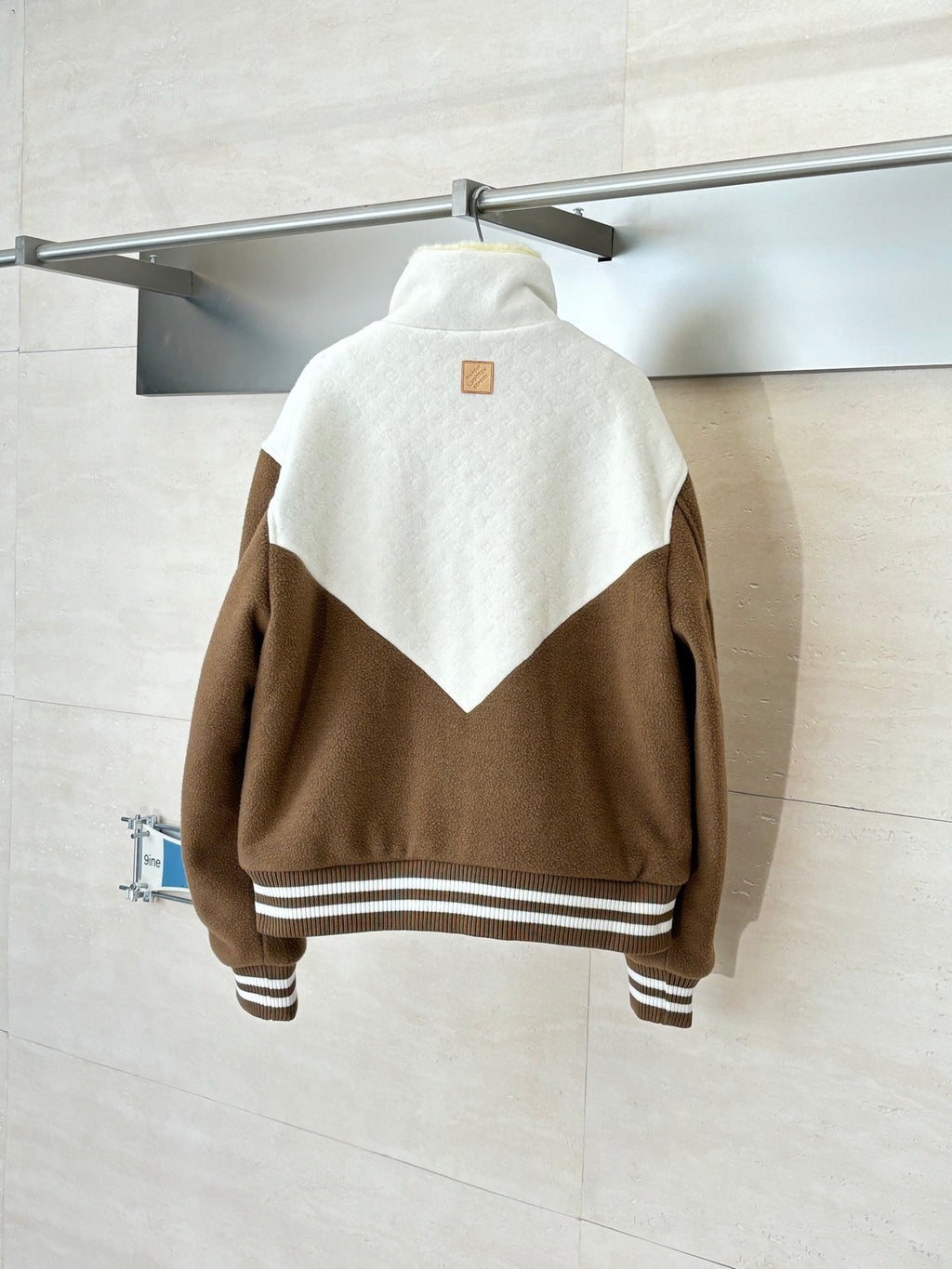Louis Vuitton long jacket back view with brown sleeves, white chevron panel, striped hem