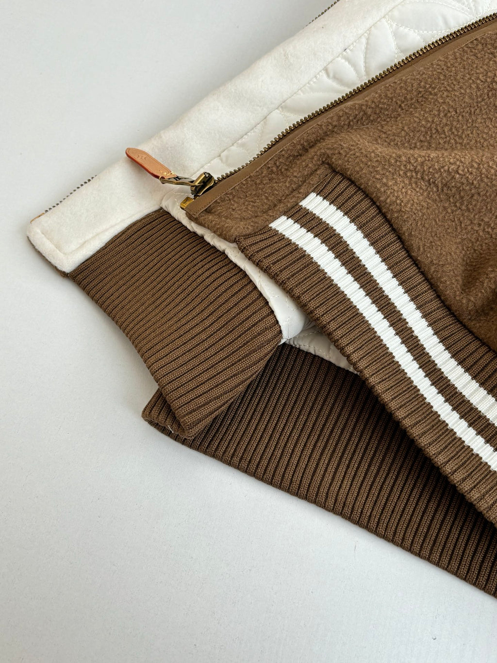 Louis Vuitton long jacket hem and zipper seam with ribbed brown trim and stripes