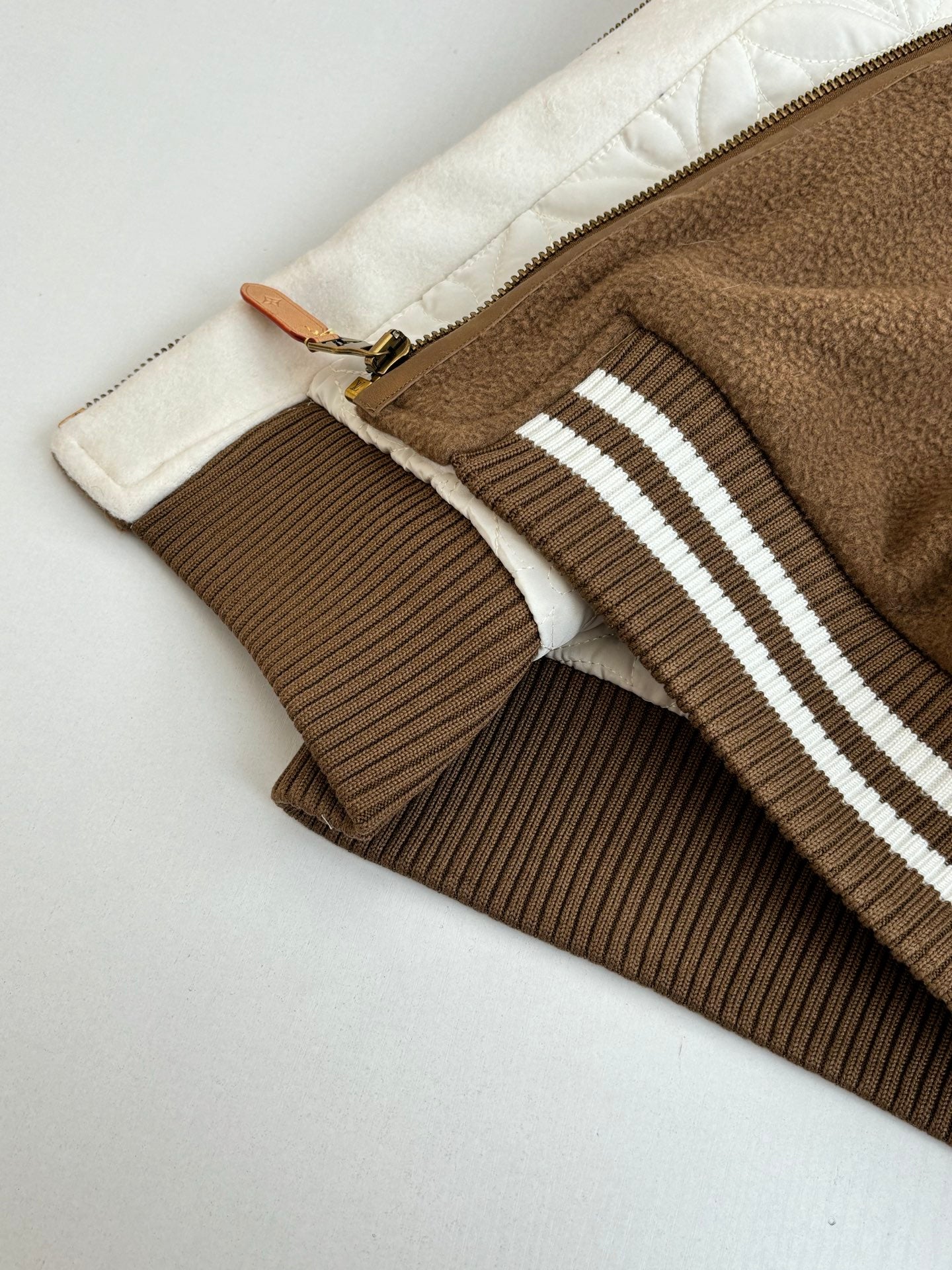 Louis Vuitton long jacket hem and zipper seam with ribbed brown trim and stripes
