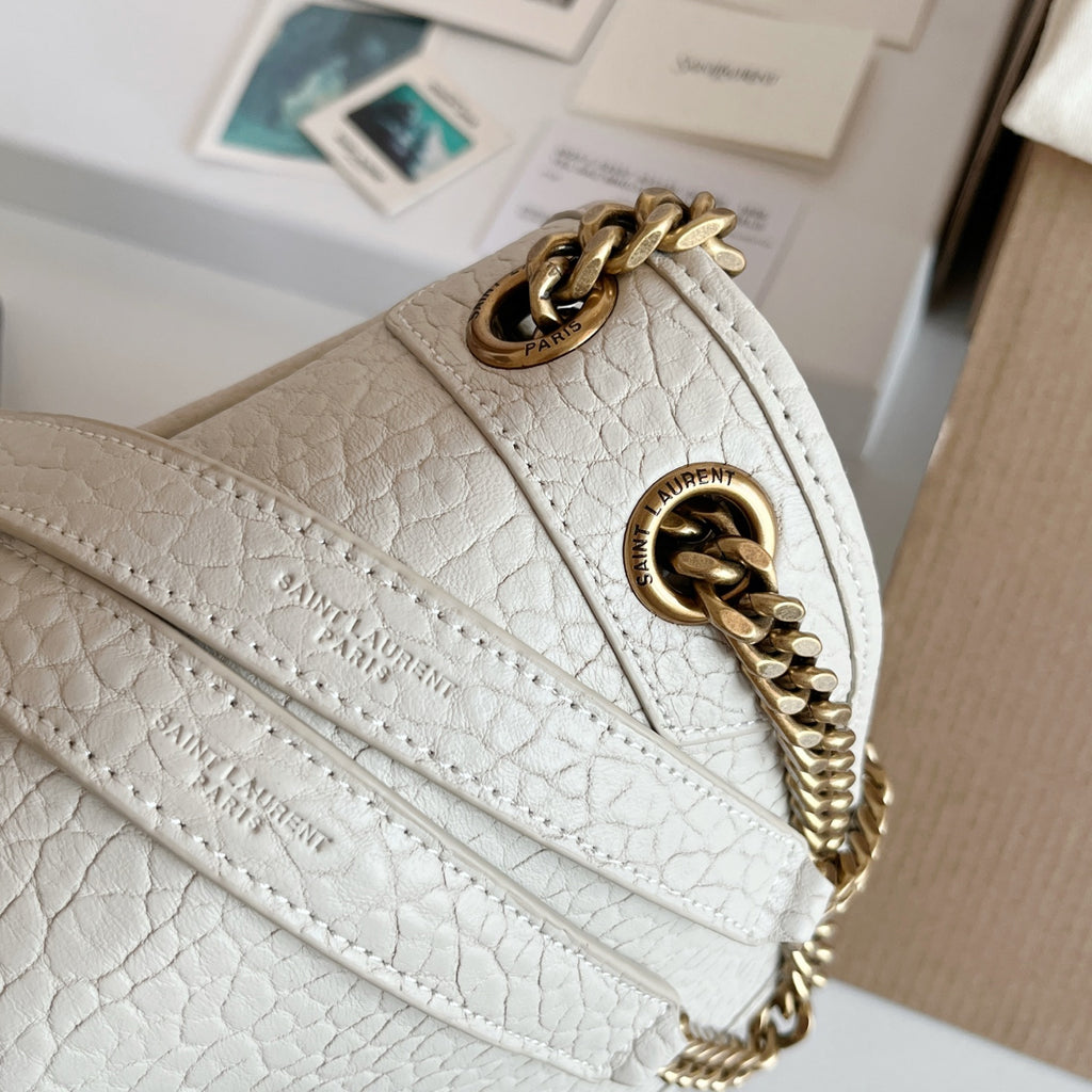YSL bag side view with white textured leather, gold-tone chain strap, logo emblem