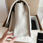 YSL bag interior view with white textured leather lining and top opening
