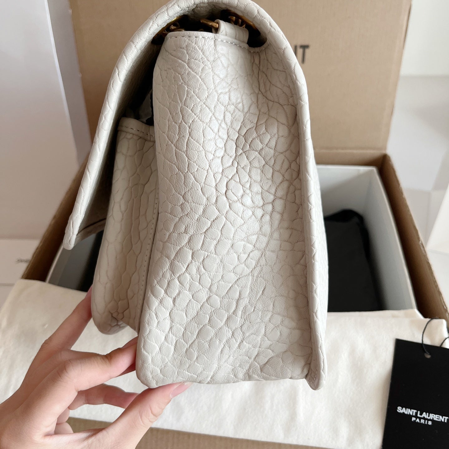YSL bag interior view with white textured leather lining and top opening