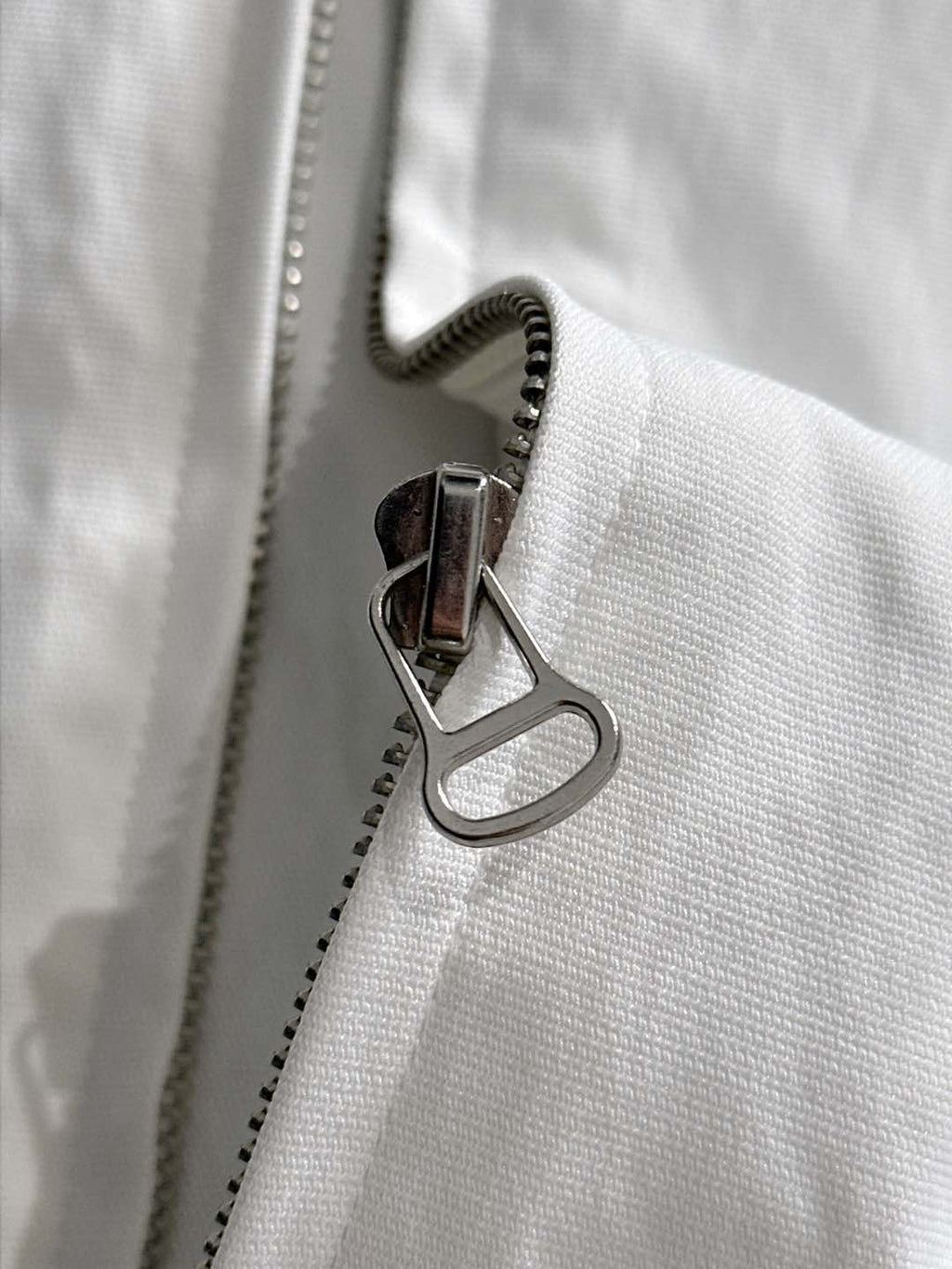 White jacket zipper with metal pull and stitched edge