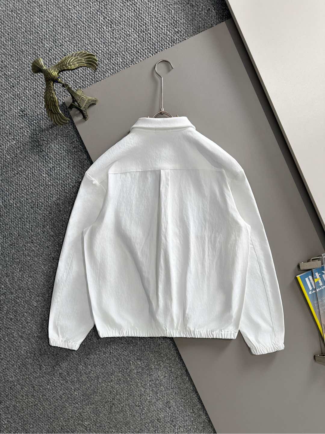 White zip jacket back view on hanger, long sleeves