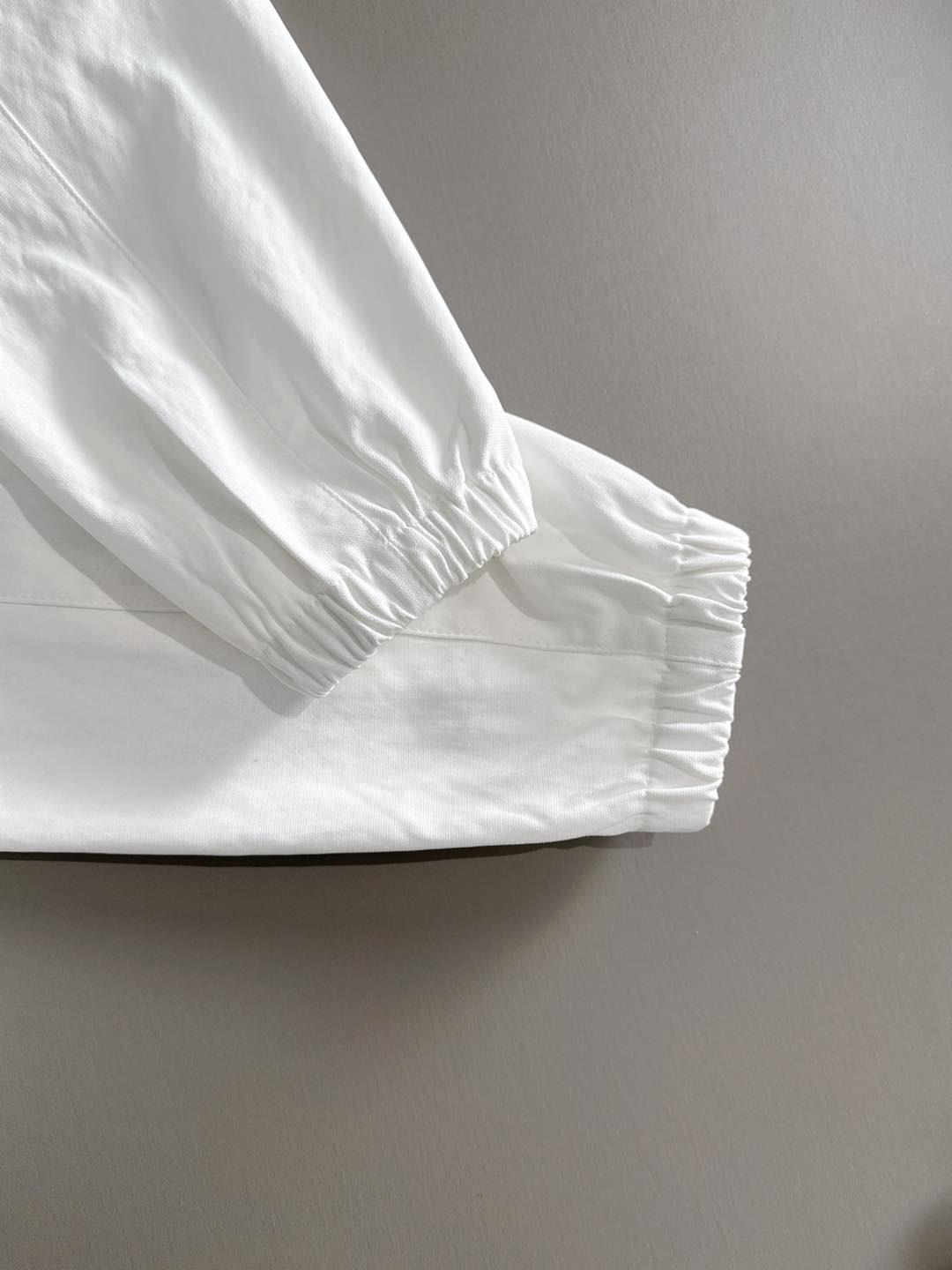 White jacket cuff with elastic hem and seam detail