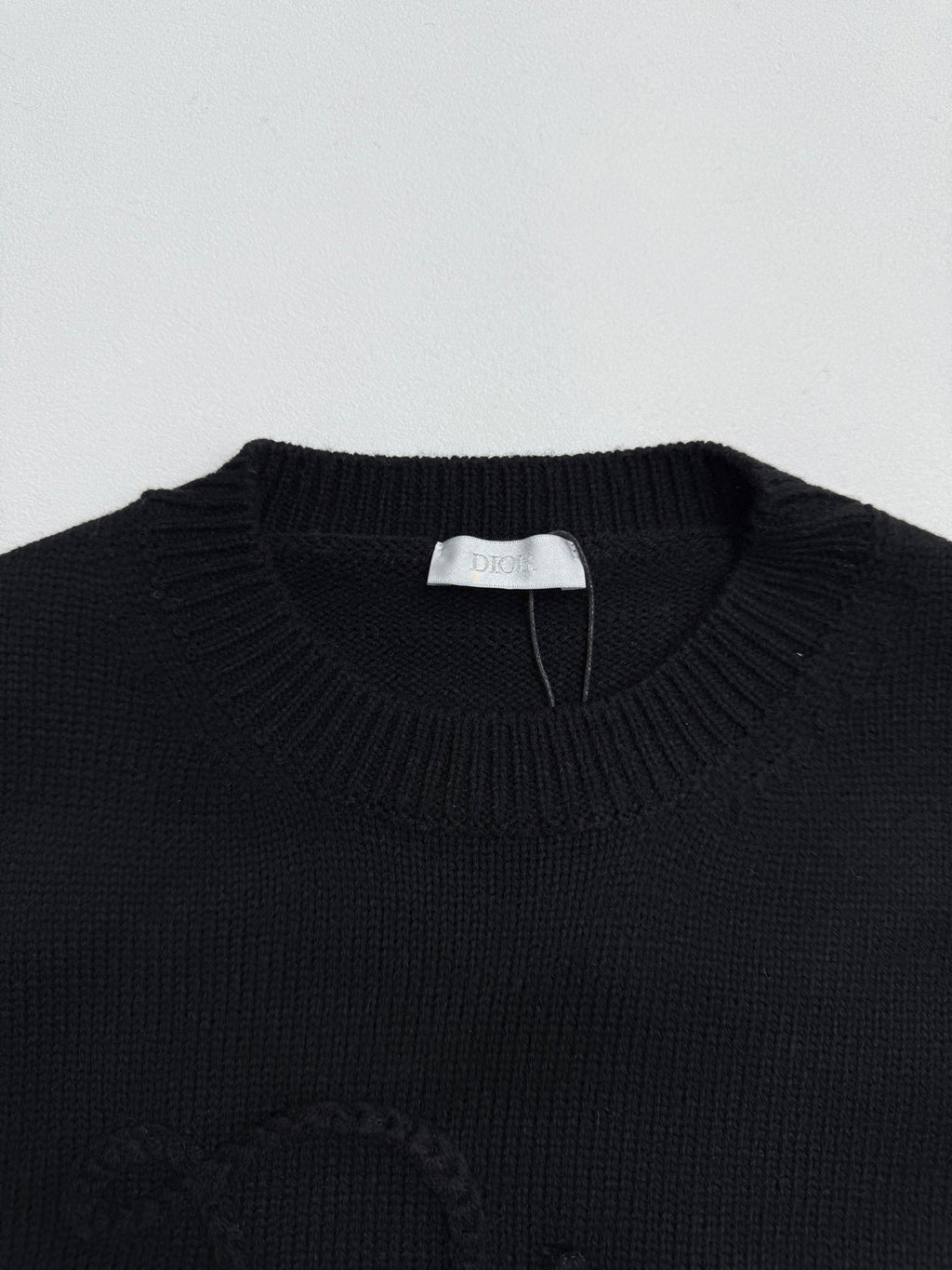 Dior knit sweater neckline with ribbed crew neck and white brand label tag