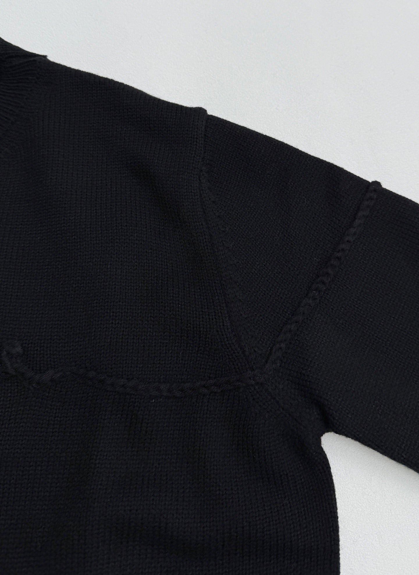 Dior black knit sweater shoulder and V-stitch seam near neckline