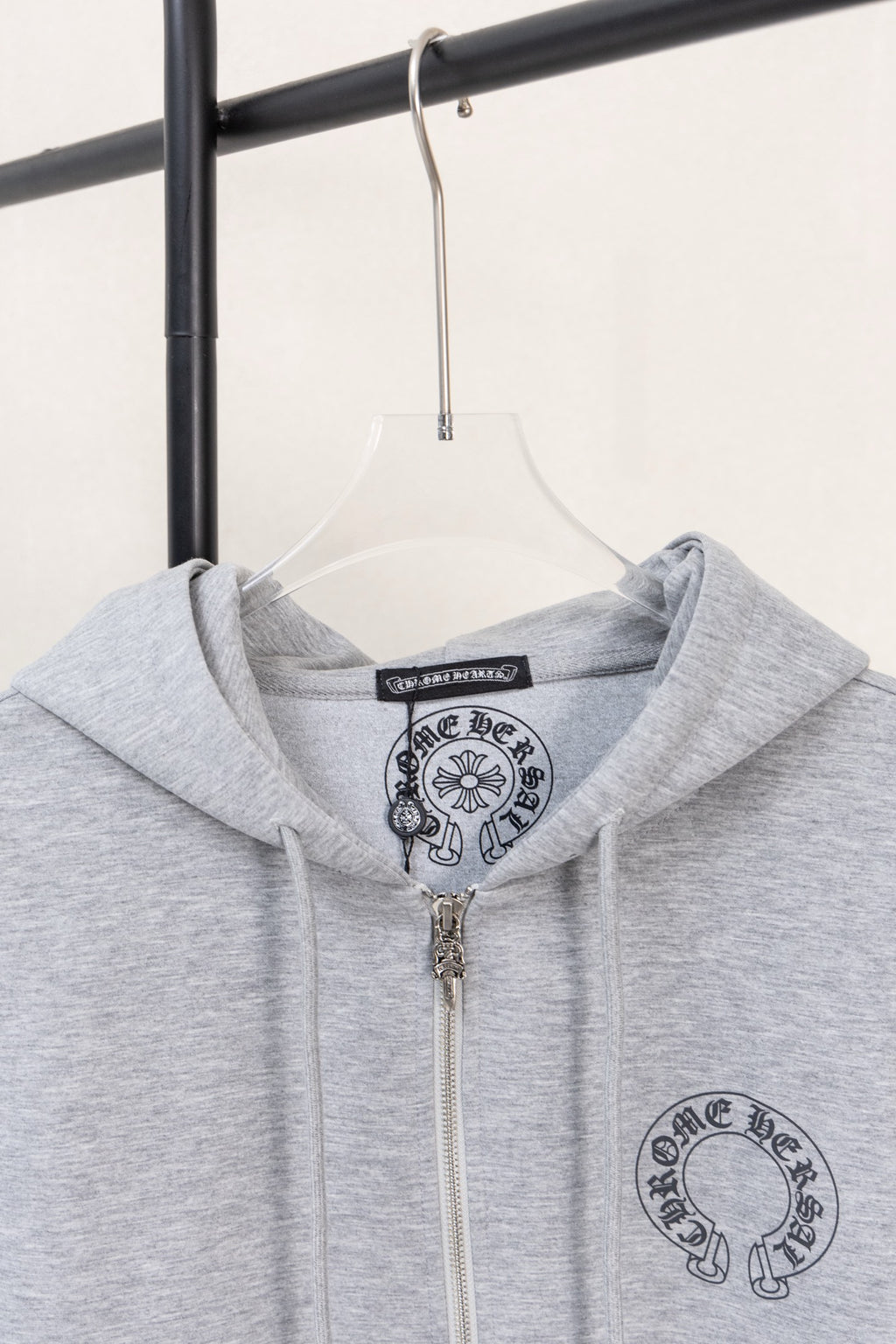 Grey zip hoodie with hood and chest graphic under the neckline.