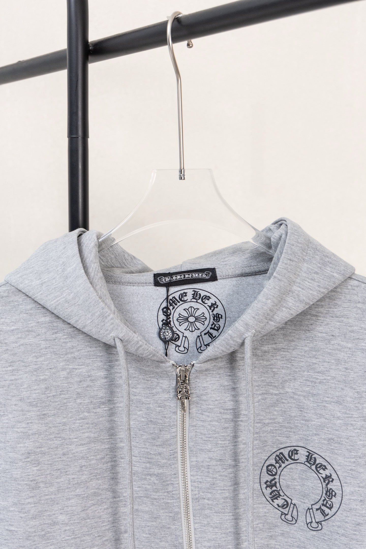Grey zip hoodie with hood and chest graphic under the neckline.