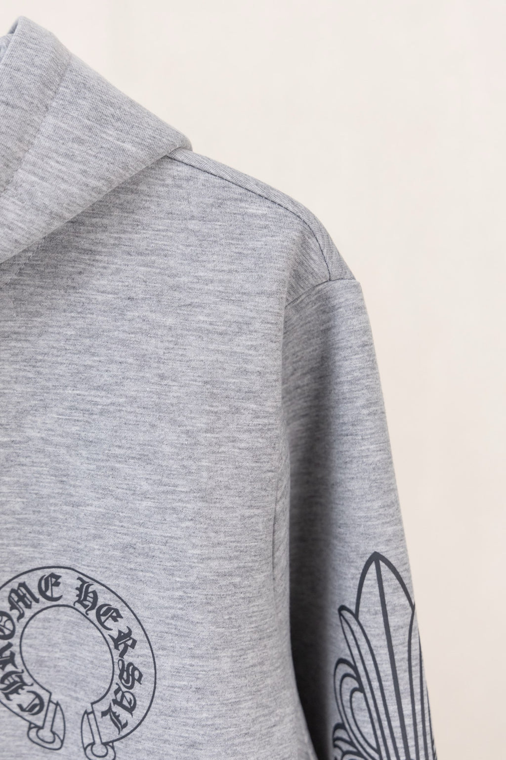Grey hoodie with hood and side sleeve graphic print.